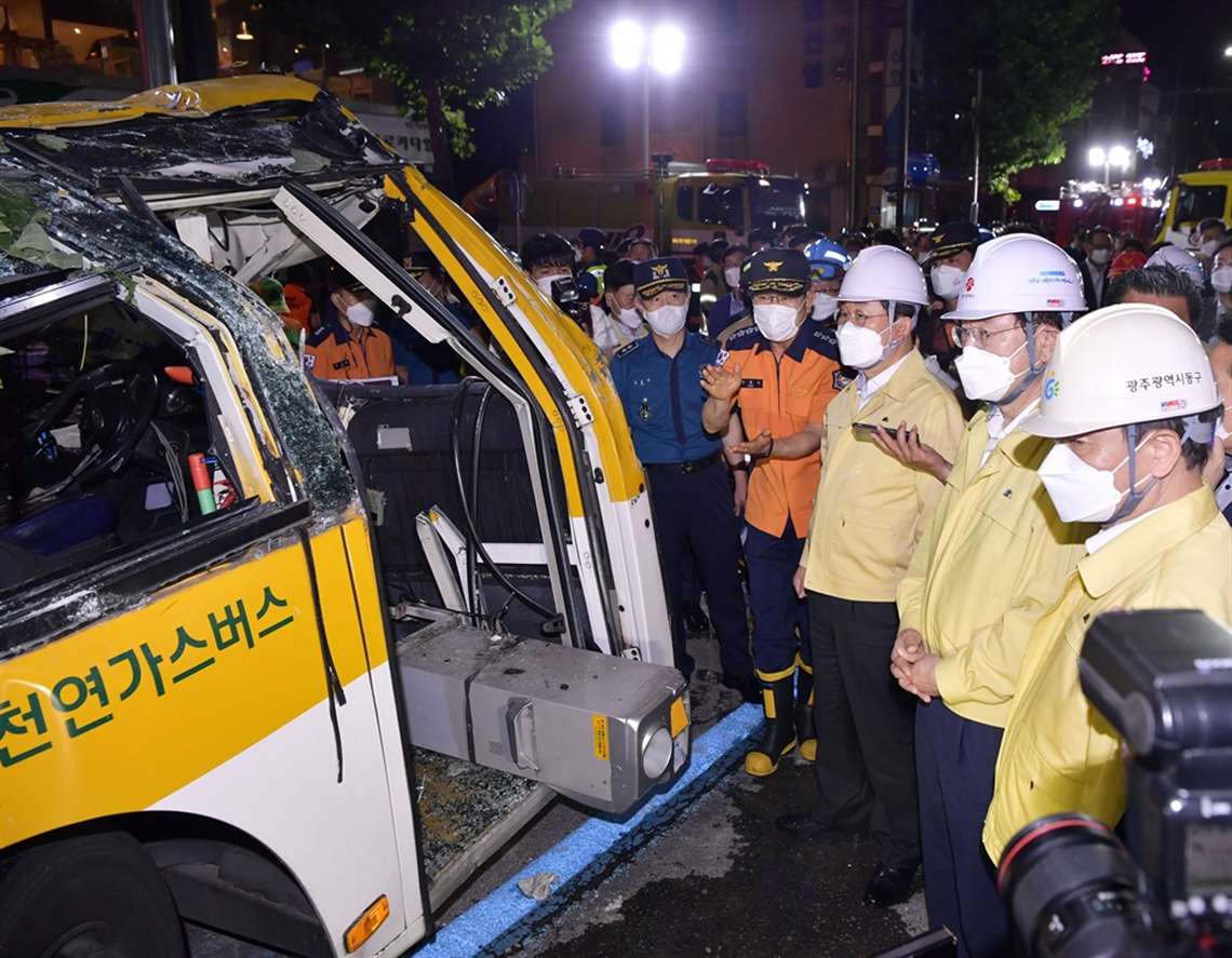 South Korean Minister of Public Administrations and Security, Yon-Hak-chul, inspects the bus that was crushed by the collapse of the building.