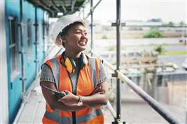 A smiling female construction worker on a construciton site.