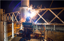 A demolition operative working at height at night