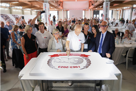 The Mantovanibenne team celebrating with a giant anniversary cake.