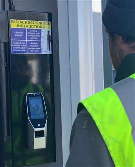 A construction worker in front of a facial recognition scanner