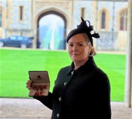 Jacqueline O'Donovan holding her OBE at Windsor Castle.