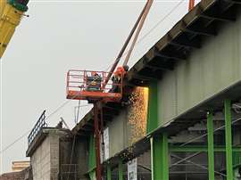 Demolition workers on an access platform cut sections of the A43 bridge