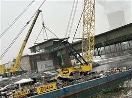 The onshore crane and floating crane working together to remove a section of the A43 bridge.