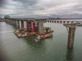An in-river section of the Champlain Bridge being removed uses barges and jacking systems