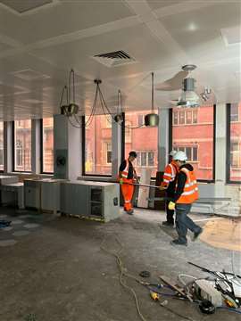 Cawarden workers carefully remove a kitchen from the office block