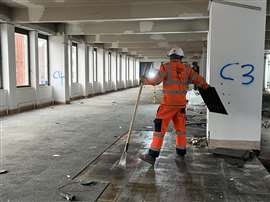 A Cawarden team member removing floor tiles during the building's stip-out
