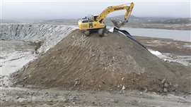 An excavator works on top of the cofferdam