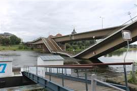 Sections of the collapsed Carola Bridge propped up by the piers in the water