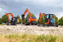 A row of orange excavators in a field