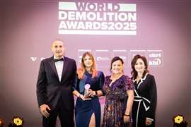 Cuatro personas vestidas de gala reciben un premio en el escenario.