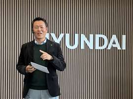 Man talking standing in front of Hyundai sign