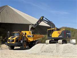 An excavator and a dumper truck in a gravel pit working