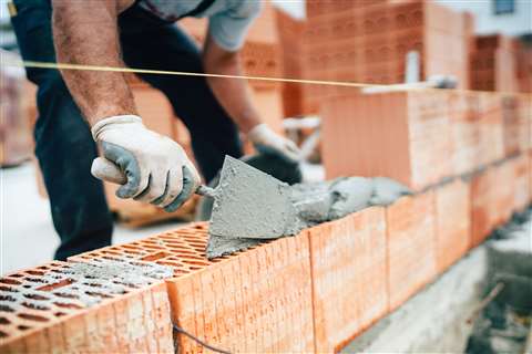 worker laying building bricks