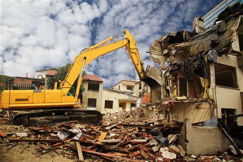 Excavator demolishing building