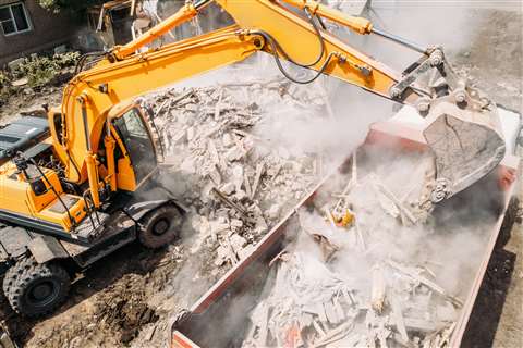 Excavator clears away rubble after demolition works