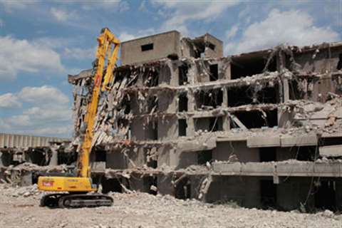 The New Holland E485B Demolition at work on the via Selva Candida building complex to the northwest 