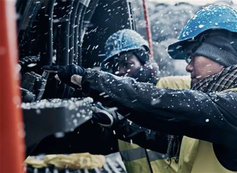 Engineers fixing a machine in the snow